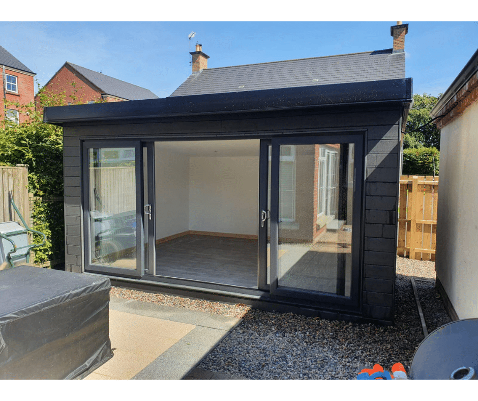 Small modern building with sliding glass doors, empty interior, designed for use as a home gym.